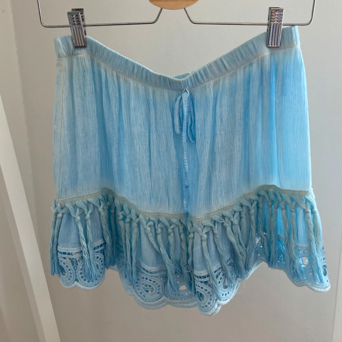 Ljusblå kortkjol med volang och spets