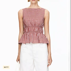 Rutig röd blus arket - Superfin ärmlös blus i rödvitt rutigt mönster med smockad midja och volang nertill. Slutsåld överallt