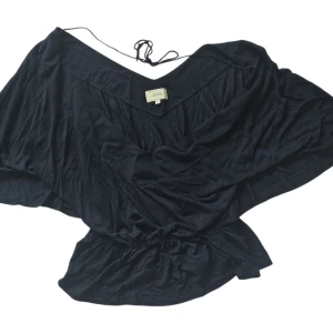 Svart omlottopp från Boomerang XL - Svart omlottopp från Boomerang i storlek XL. Toppen har djup v-ringning, knytband i nacken och lös passform med resår i midjan. Perfekt för dig som gillar en avslappnad men ändå snygg stil.