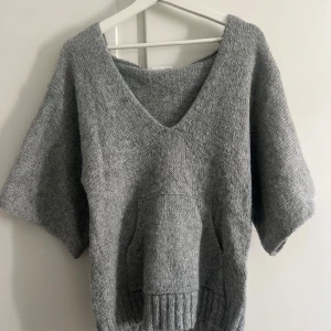 Off shoulder kortärmad grå stickad tröja - Säljer min stickade tröja köpt från Stella.vasteras eftersom den är lite för stor på mig (är 154 cm). De tre sista bilderna är inte mina. Tröjan har en oversized fit, öppen rygg och en djup V-ringning framtill så man nästa måste ha ett linne under. Den passar typ s-m så jag vet inte riktigt vad jag tänkte när jag köpte den och trodde den skulle passa mig 💔💔