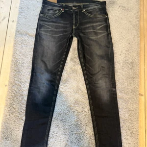 dondup george  - Snygga svarta jeans från dondup med kontrastsömmar och klassisk femficksdesign. Modellen är george. Någon tråd som gått upp på fickan men annars i nära nyskick! Väldigt sällsynt färg!