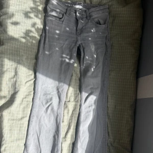 Grå bootcut jeans från lager 157 - Snygga grå jeans från lager 157med klassisk femficksdesign och bootcut-ben. Jeansen har en ljusgrå tvätt och normal passform, perfekta för dig som gillar en avslappnad men ändå stilren look. Tillverkade i mjukt denimtyg för skön känsla hela dagen.