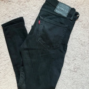 Svarta Levi's 512 slim jeans - Svarta Levi's 512 jeans med rak passform och klassisk femficksdesign. Jeansen har en snygg svart tvätt, normal midja. Tillverkade i mjukt bomullsmaterial med lite stretch för extra komfort. Perfekta för en clean och stilren look.