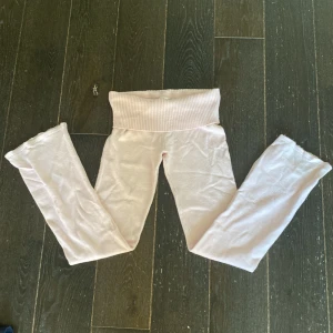 Ljusrosa mjukisbyxor från Gina Tricot - Supermysiga ljusrosa mjukisbyxor från Gina Tricot med bred ribbad midja. Byxorna är i mjukt material och har en relaxed passform, perfekta för chill dagar hemma eller när du vill vara extra bekväm.