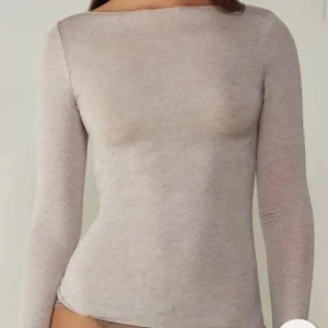 Intimissimi Beige långärmad topp med båtringning - En stilren beige långärmad topp med båtringad hals. Toppen har en slim passform och är tillverkad i ett mjukt, stretchigt material som sitter snyggt mot kroppen. Perfekt att styla med jeans eller kjol för en clean look.