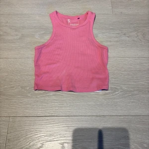 Två ribbade croppade linnen - Säljer två croppade linnen i ribbad bomull, ett i ljusrosa och ett i cerise. Från H&M och New Yorker