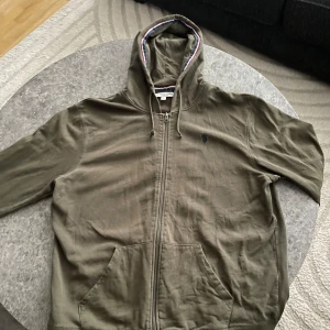 Olivgrön hoodie från U.S. Polo Assn L - Olivgrön hoodie från U.S. Polo Assn. Säljer denna för den kommer aldrig till användning. Det står XL men den har krympt, den passar även L och säkert M
