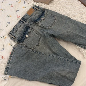 Blå 90's bootcut jeans från 157 - Säljer ett par klassiska blå bootcut jeans från 157 i storlek S. Jeansen har en snygg tvättad look, fem fickor och silverfärgade knappar. Modellen är inspirerad av 90-talet och har full längd. Perfekta för dig som gillar retrovibbar och bekväm passform.