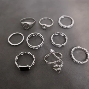 9-pack silverfärgade ringar - Säljer ett set med 9 st silverfärgade ringar i olika former och mönster. Perfekt för att mixa och matcha till din egen vibe. Materialet är zink alloy. (304)