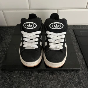Adidas Campus svarta sneakers strl 36 - Säljer dessa svarta adidas campus 00s. dom är använda ett fåtal gånger köpte dom i början så dom e relativt nya säljer då de inte kommer till användning så mycket ingår även svarta snören.