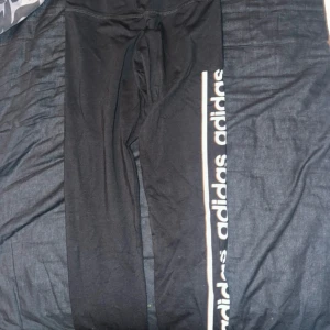 Svarta Adidas träningsbyxor  - Svarta leggings från Adidas i storlek XS med vit logga längs ena benet. Tillverkade i stretchigt Climalite-material som andas. Perfekta för träning eller chill och tight passform. Dem är försmå för mig och därför aldrig använda 