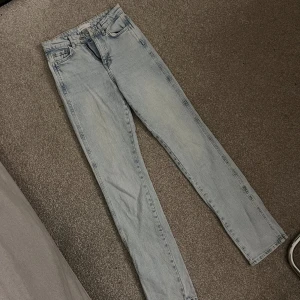 Ljusblå high waist skinny jeans - Säljer ett par ljusblå skinny jeans med hög midja. Klassisk femficksmodell i mjukt denimtyg, raka ben och enkel design utan slitningar. Perfekta för dig som gillar en clean och stilren look.