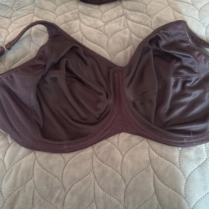 Svart sport bh från Freya - Snygg svart sport bh från Freya med bygel och justerbara axelband. Tillverkad i ett glansigt material som ger en lyxig känsla. Perfekt för dig som vill ha extra stöd och stil vid poolen eller stranden.