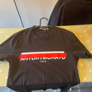 Antony Morato t-shirt - Svart Antony Morato t-shirt med röd/vit tryck. Köpare står vid frakt 📦 