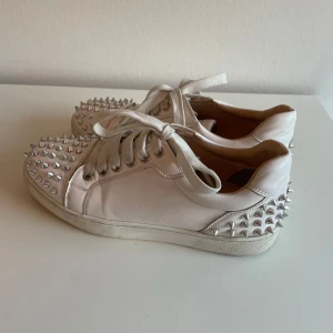 Christian Louboutin skor - Jag säljer ett par vita Christian Louboutin skor med silvriga spikar i storlek 38 passar 39. Dom har klassisk röd sula och ett bra pris då dom som nya kostar upp mot 10 000kr. Kontakta mig vid frågor eller om ni vill ha fler bilder. Priset går att förhandla.