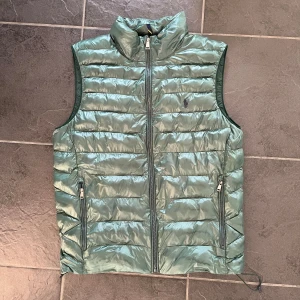 Grön dunväst från Polo Ralph Lauren - Snygg grön dunväst från Polo Ralph Lauren med quiltad design och hög krage. Skriv vid frågor! Pris kan diskuteras vid snabb affär!