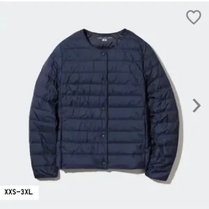 Mörkblå dunjacka från Uniqlo - Säljer en stilren mörkblå dunjacka från Uniqlo. Jackan är ultralätt, har rund halsringning och knäpps med knappar framtill. Perfekt för lager-på-lager och enkel att bära med sig. Passar dig som gillar minimalistisk och clean stil.