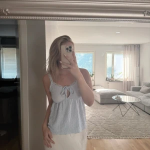 Ljusblå linnetopp med knyt fram - Supersöt ljusblå linnetopp med smala axelband och knytning framtill. Toppen har en lätt skrynklig struktur och en liten öppning under knytet. Ny med lapp 🌸