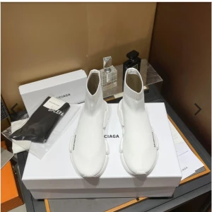 Vita Balenciaga Speed sneakers - Säljer ett par vita Balenciaga Speed sneakers med sockliknande design och chunky sula. Skorna är i stretchig textil med Balenciaga-logga på sidan och sulan. Riktigt clean look och superbekväma för dig som gillar streetstyle.