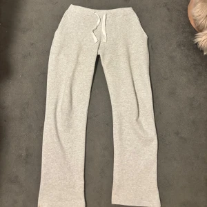 Grå mjukisbyxor från russemurch  - Snygga ljusgrå mjukisbyxor med raka ben och dragsko i midjan. Perfekta för chill dagar eller när du vill vara bekväm men ändå se fräsch ut. Mjukt material och klassisk passform.