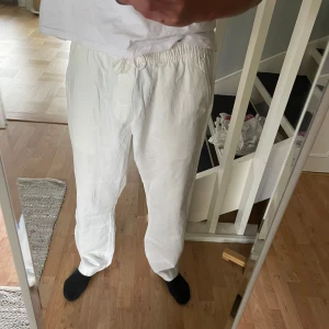 Vita linnebyxor - Säljer ett par sprillans nya vita linnebyxor från lager 157.  Som du ser så är lappen kvar och dem är helt oanvända. Pappa köpte fel storlek så dem är lite för stora för mig. Det är M Medium. Det är en smidig knytning på byxorna, de är även väldigt luftiga och sköna.  Nypris på lager 157 är 200 kronor 