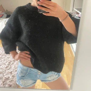 Ljusblå jeansshorts med rosett G Smack - Supersnygga ljusblå jeansshorts från G Smack med slitna detaljer, nitar och glittrande stenar framtill. Shortsen har låg midja, dubbla knappar, råa kanter och söt liten metallrosett bak. Perfekta för sommaren och ger en cool vibe till din outfit.