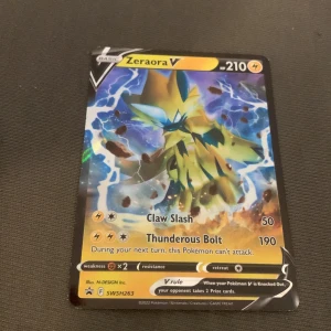 Zeraora V - Cool Pokémonkort med Zeraora V! Med kraftfulla attacker som Claw Slash och Thunderous Bolt är detta kort perfekt för dig som vill ta din samling till nästa nivå. Snygg design och passar både samlare och spelare.