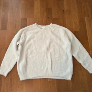 Vit lurvig stickad tröja H&M - Mysig vit stickad tröja från H&M i storlek S. Tröjan har en rund halsringning och är långärmad med en fluffig och mjuk känsla. Perfekt för lager-på-lager och chill dagar. Enkel och stilren design som funkar till det mesta.