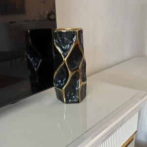 Svart modern vas med guldigt geometriskt mönster i suveränt nytt skick  - Bilderna visar en svart och guld dekorativ vas med geometriskt mönster. 