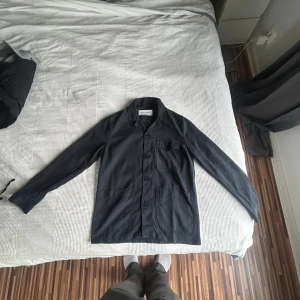Mörkblå overshirt från A Day's March - Säljer min Overshirt från A Day's March då den var för liten för mig, använt en gång så precis som ny. Kan släppa billigare vid snabb affär
