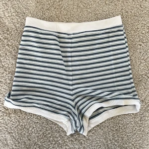 Randiga shorts från H&M - Superfina randiga shorts från H&M i vitt och blå. De är högmidjade med bred resår i midjan 