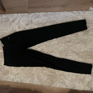 Svarta skinny jeans från Vero Moda - Svarta skinny jeans från Vero Moda Denim i storlek XS. Klassisk femficksmodell med smal passform och normal midja. Snygga och enkla att matcha till olika outfits. Jeansen har dragkedja och knapp framtill.