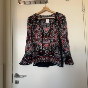 Odd molly blus  - Säljer en superfin blus i en svart bottenfärg men ett fint mönster i färgern rosa, grå och beige. Från märket Odd Molly i storlek 0 som ungefär motsvarar en storlek XS, men den är rymlig i storlek. Fint skick, men tråddraning finns. 