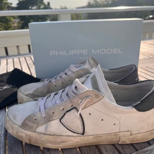 Philippe Model vita sneakers med mockadetaljer - Og box samt dustbag. 7/10 skick inga defekter. Tveka inte att skriva vid frågor. Köpta på ph 