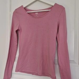 Rosa långärmad topp från 157 XS - En basic rosa långärmad topp från 157 i storlek XS. Tillverkad i mjuk bomull med lite stretch för en skön passform. Enkel design med rund halsringning, perfekt att styla med jeans eller kjol. Köpte för 30kr säljer för 10kr🩷 Använd typ 2 gånger flitit så den är i princip i nyskick. Inga defekter