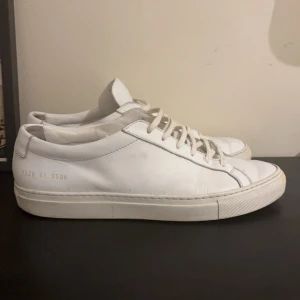 Vita Common Projects sneakers i skinn - Vita sneakers från Common Project | Storlek 41 (fits 42) | Bra skick 8/10, men använda som ni ser. Smuts som är enkelt o tvätta bort | Vid snabb affär kan jag sänka.