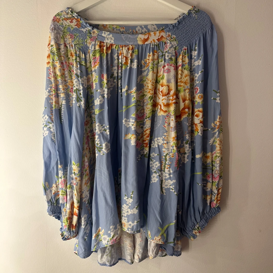 Blommig blå blus med vida ärmar