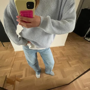 Ljusblå stickad tröja - Supermysig ljusblå stickad tröja med relaxed fit och rund hals. Tröjan har långa ärmar och är ribbstickad vilket ger en snygg struktur. Perfekt att slänga på sig när det är lite kyligare ute.