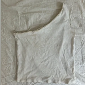Vit ribbad oneshoulder topp - Snygg vit ribbad topp med oneshoulder-design. 