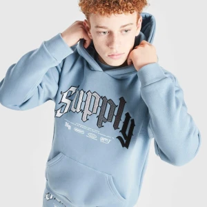 Blå hoodie och byxa Supply & Demand. Tracksuit junior 14Y - Helt nytt set! Tvättat en gång efter en användning av 13 åring som ångrade sitt köp. Kvitto 880 kronor finns från JD sports, från maj i år. Ljusblå hoodie från Supply & Demand med stor broderad text 'Supply' i svart, grått och vitt på bröstet. Klassisk känguruficka, huva och ribbade muddar. Mjuk insida och avslappnad passform, perfekt för chill dagar.