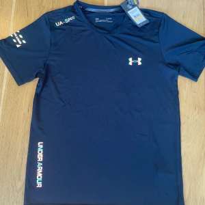 Svart Under Armour Tröja UA-Spec - Helt ny Under Armour UA-Spec träningströja, Storlek L men skulle säga att den passar M