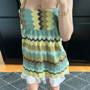 Glittrig zigzag linnetopp i grönt och blått - Supersnygg topp med smala axelband och glittrigt zigzag-mönster i nyanser av grönt, blått, svart o brunt. Toppen har en loose passform och är perfekt för varma dagar. Materialet är stickat och har en lätt skimrande finish som gör att du sticker ut. Skriv om frågor eller pris förlag💓