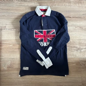 Morris långärmad piké  - En snygg långärmad piké i bra skick utöver det lilla hål som syns på bild 3 därav extremt lågt pris. Hör av er vid frågor annars fritt fram att använda ”köp nu”.