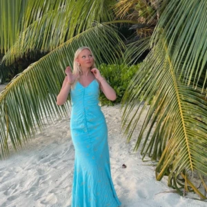 ADOOORE Ljusblå långklänning med blommor - Superfin ljusblå långklänning med smala axelband och v-ringning. Klänningen har ett blommigt mönster i gult och sitter figurnära upptill med lätt utsvängd nederdel. Perfekt för sommarkvällar eller strandhäng.