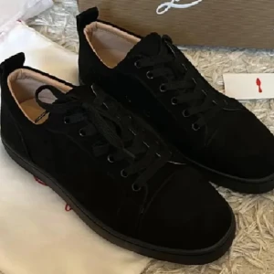 Christian Louboutin  - Snygga svarta sneakers från Christian Louboutin i mocka med klassisk röd sula och diskret logga undertill. Skorna har rund tå, snörning och en stilren design som passar perfekt till streetwear eller en mer dressad look.