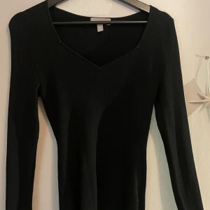 Svart ribbad långärmad tröja - Snygg svart ribbad tröja med v-ringad hals och lång ärm. Den har en tight passform