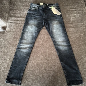 Slim fit jeans från LAB Industries - Snygga slim fit denim jeans från LAB Industries i mörkblå tvätt med klassiska fem fickor. Jeansen har en smal passform och är gjorda i en stretchig denimblandning av bomull, polyester och elastan. Perfekta för dig som gillar en modern och stilren look.