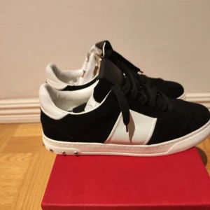 Valentino Garavani svartvita sneakers - Säljer mina valentino flycrews för att dom är för små för mig,köpte dom i våras och har använt dom typ 10 gånger,på vänster sulan är de ett bränn märke vill gärna bli av me dom så fort som helst  vill minst ha 2500 kan gå ner lite i pris, storlek en stor 38 men innermått 24,5cm
