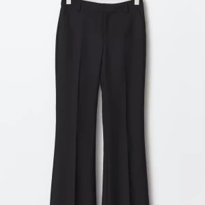 Svarta bootcut kostymbyxor - Snygga svarta kostymbyxor med bootcut-snitt och pressveck. Byxorna har hällor för bälte och klassisk midja. Perfekta för en clean och stilren look, passar till både sneakers och boots. använt 1 gång.