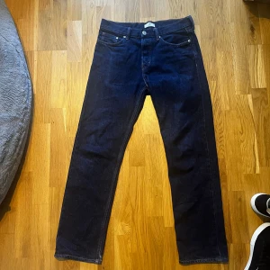 Mörkblå relaxed fit jeans från H&M - Säljer ett par mörkblå jeans från H&M med relaxed fit. Klassisk femficksmodell med raka ben och normal midja. Jeansen är tillverkade i kraftigt denimtyg och har snygga kontrastsömmar. Perfekta för en chill och avslappnad stil.